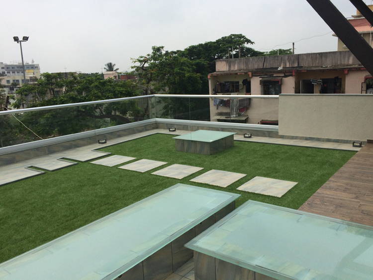 Lush natural grass covering a modern rooftop garden with city view