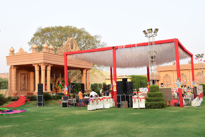Event space with manicured natural grass surrounded by decorative lights and seating.
